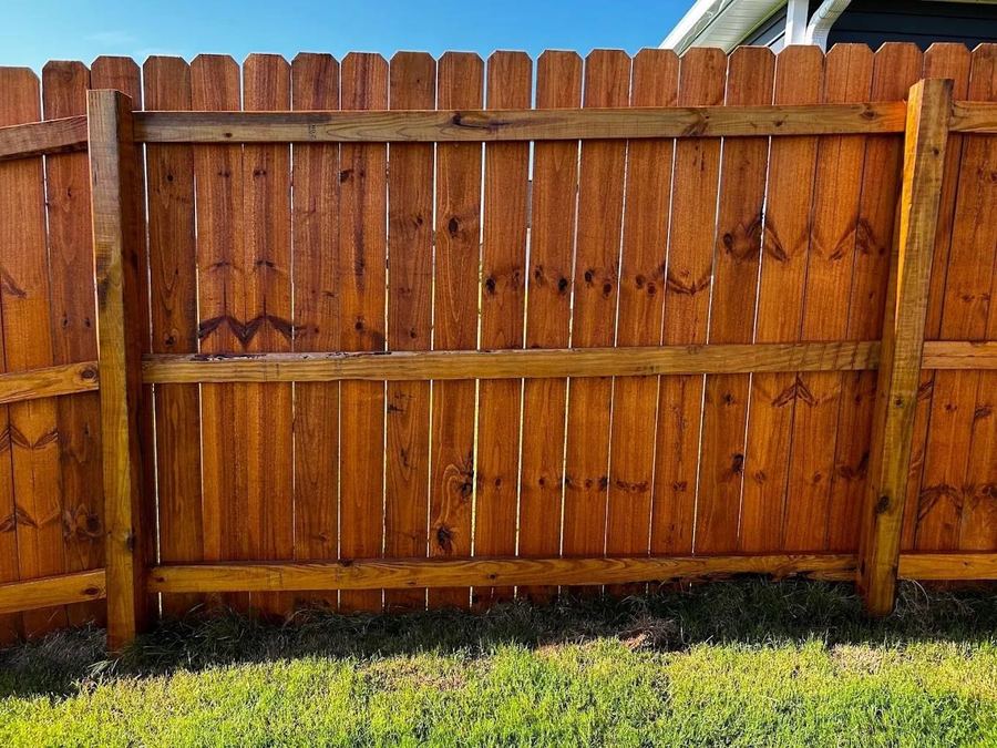 Close view of freshly stained fence boards showing the wood grain