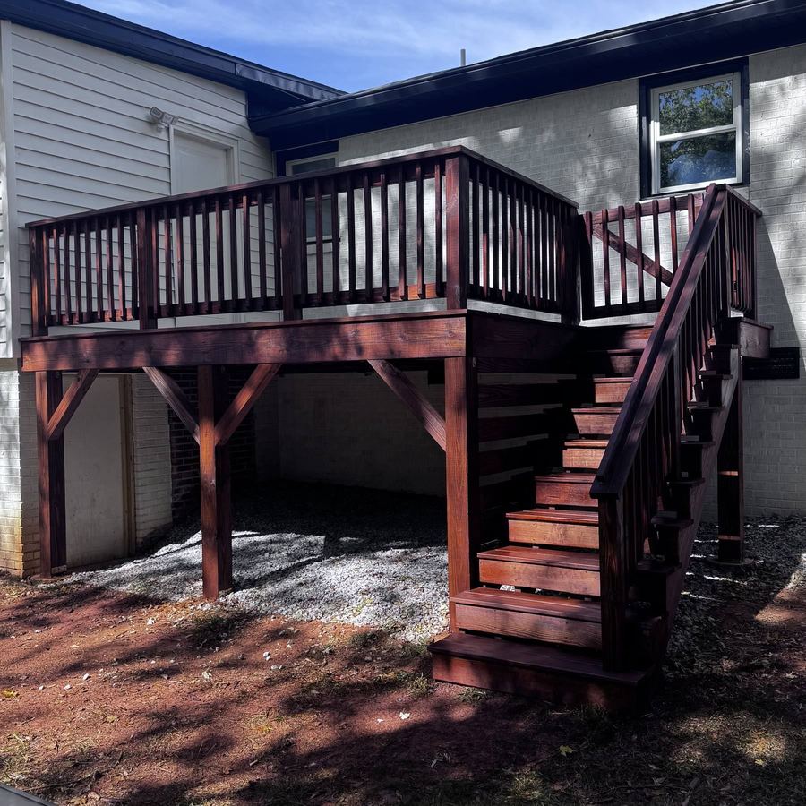 Elevated deck with rails and a full stair run stained a deep red-brown