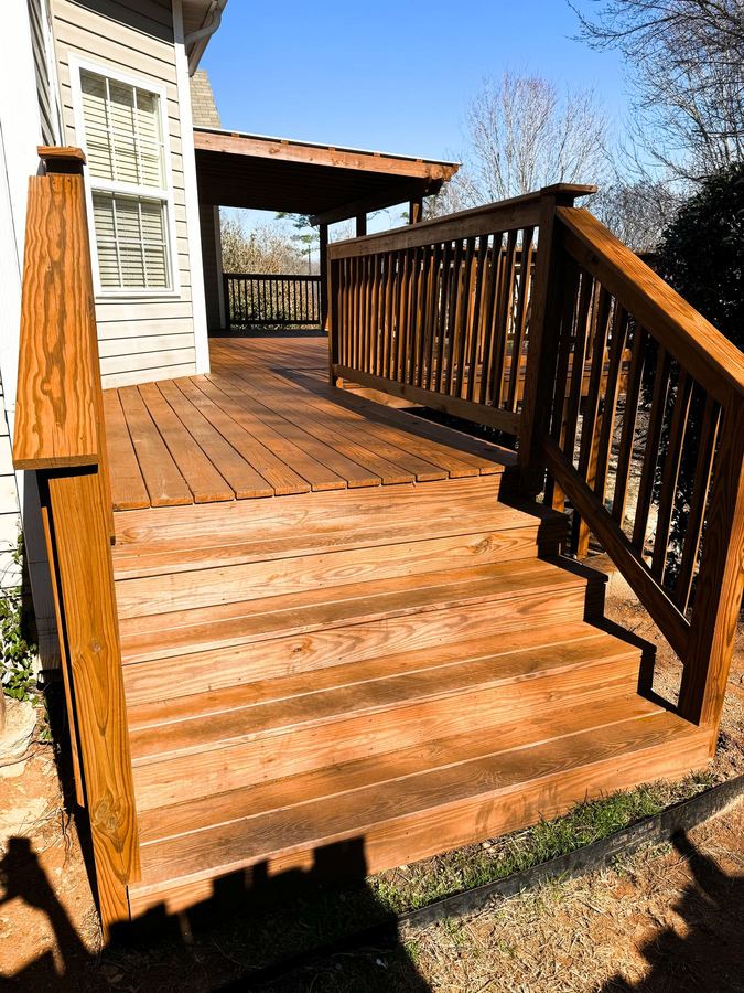 Wide stained deck stairs leading up to a multi-level deck