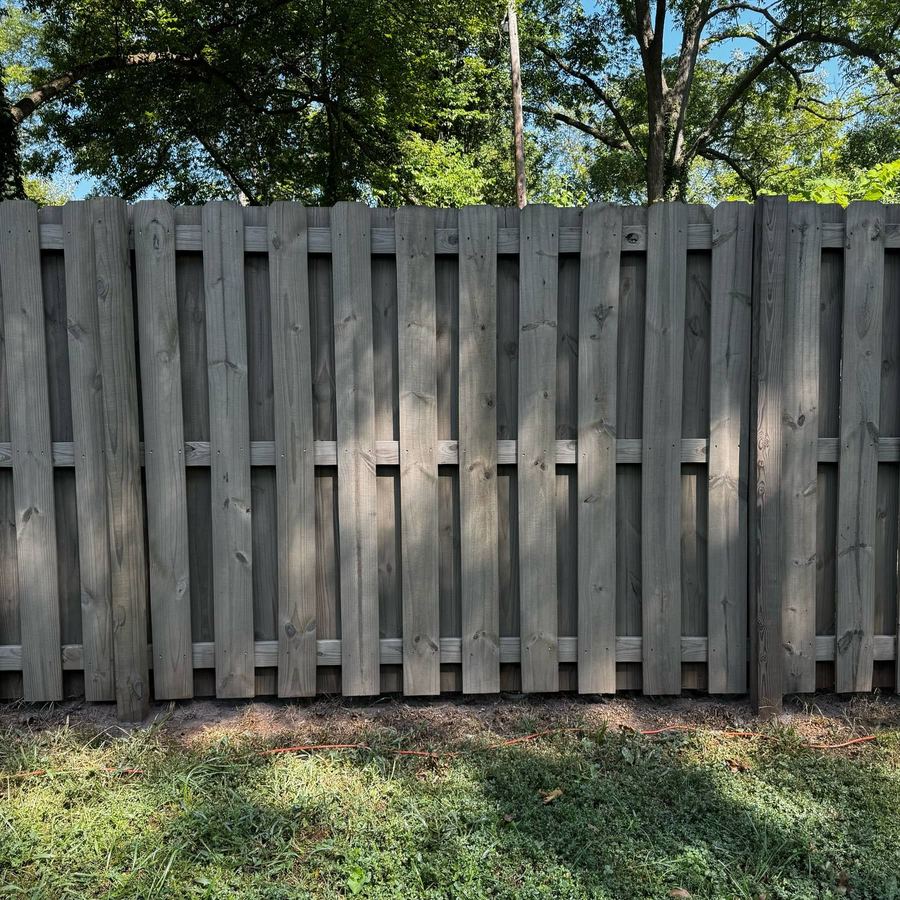 Shadowbox fence stained a soft grey under tree cover
