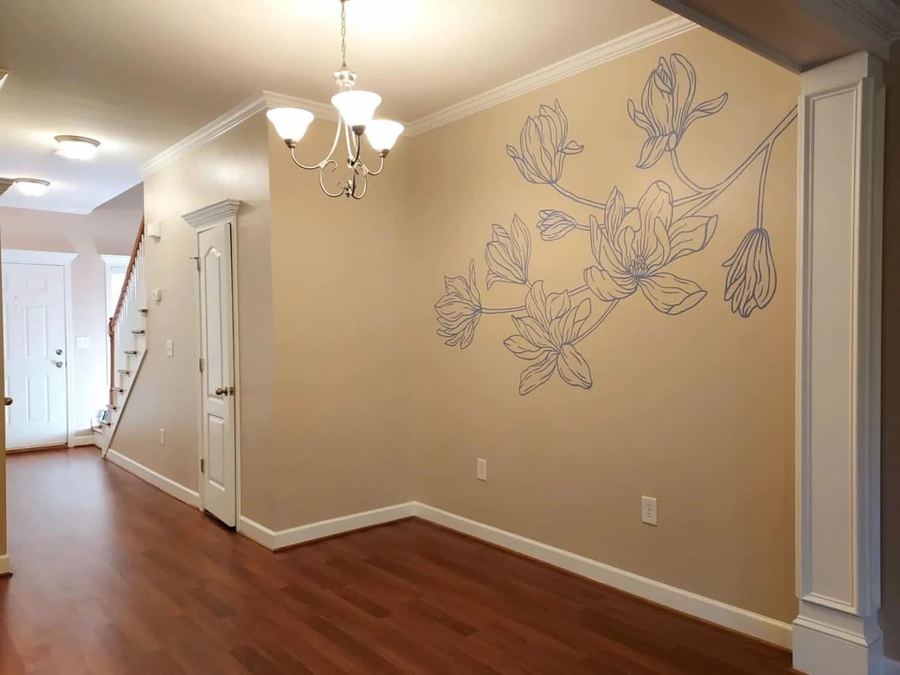 Bedroom wall with a white floral mural painted over a dark accent wall