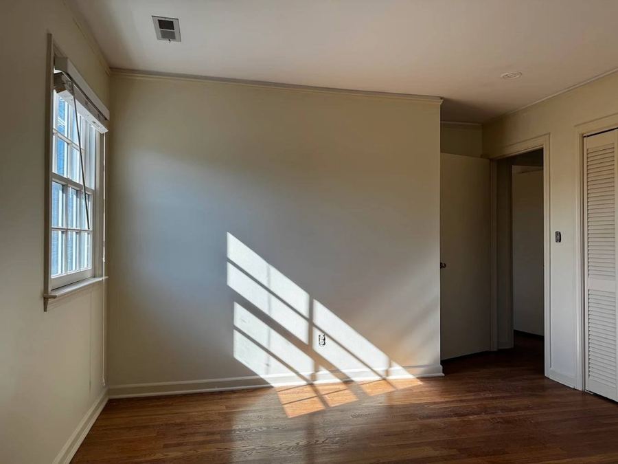 Painted bedroom with morning light on the wall and wood floors
